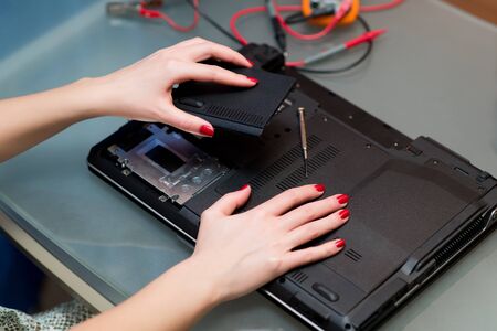 girl removes or installs a laptop cover during repair, close up, no faceの写真素材
