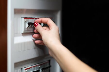 girl is going to turn off the electricity in the house using a power switch