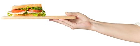 Female hand holds a sandwich with fresh herbs on a wooden tray. Isolated