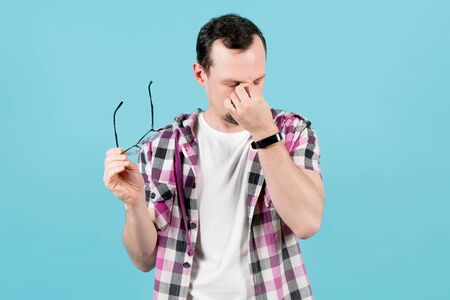 the man took off his glasses and kneads the corners of the eyes from fatigue and strain