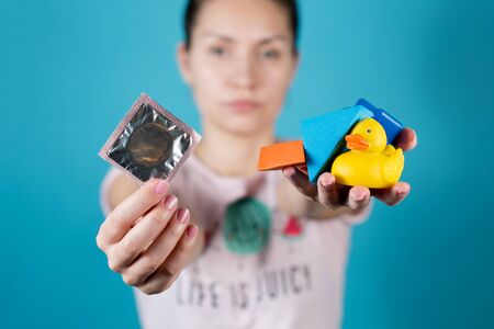 A young girl holds out a condom and a handful of children's toys into the camera. This symbolizes...