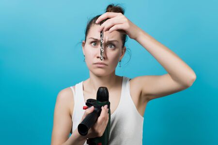 The girl is trying to insert the drill into the drill chuck upside down. Girl and male work toolの写真素材
