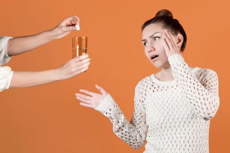 The girl really wants to get a pill for the headache that she is offered. A friend or mother offers...