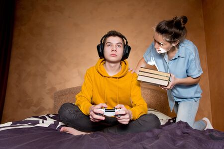 The girl scolds a young man who is passionate about a computer game. She is trying to convey a thought to him while he is busy playingの写真素材