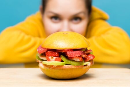 fresh vegetarian burger lies in front of the girl on the table. close upの写真素材