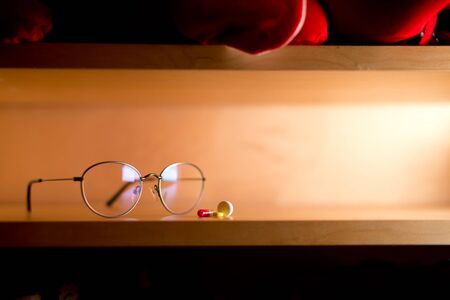 glasses for vision and a small portion of tablets lies on a shelfの写真素材