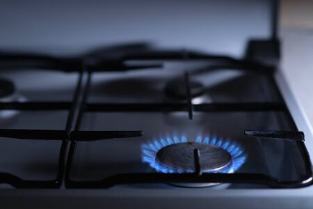 Fire burns on an old gas stove at night, close up