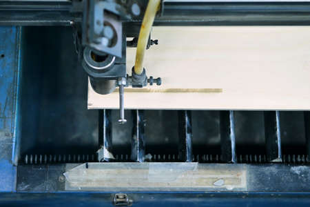 Top view of the working area of a laser engraving machine while burning a picture on a wooden workpieceの写真素材