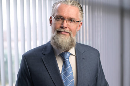 Portrait of an adult gray-haired man in the office. A mature company executive smiles pleasantly and looks into the camera. Solid boss in the officeの写真素材