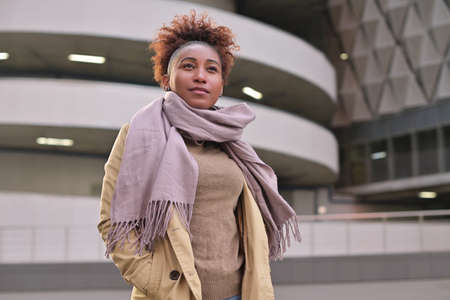 Young black woman posing against the backdrop of urban landscapes.の写真素材