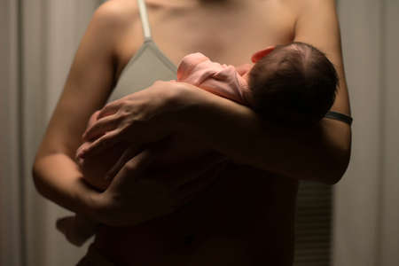 Newborn baby in mothers arms, close upの写真素材