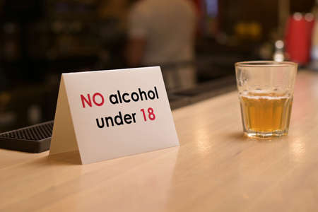 close-up of a sign on the restriction of the sale of alcohol due to the age of eighteen yearsの写真素材