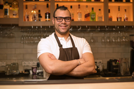 portrait of a confident smiling bartender at the bar in a restaurantの写真素材