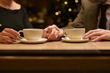 Hands of two people and cups of tea at the bar. Close-up of the hands of twoの写真素材