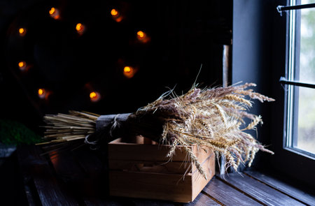 Autumn bouquet in a wooden box on the background of a garland. Heart of lights. Dried flowers and...