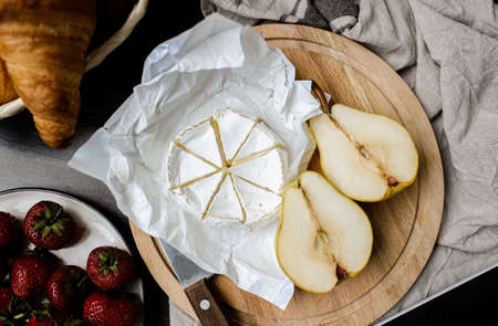 Cheese, Strawberry and sliced pieces of pears on a plate. Round piece of cheese for dessert. Fruit and cheese on a plate. Camembert cheese and Strawberry.の写真素材