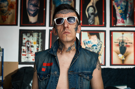 Tattoo artist in denim vest in his studioの写真素材