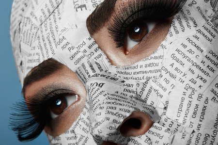 Asian Girl with long Eyelashes and Newspaper on her Faceの写真素材