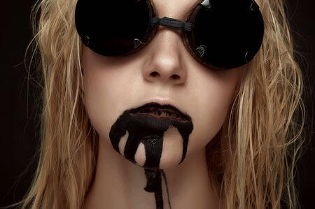Beauty female Model with Sunglasses and Oil from her Mouth. Halloween Face Art Makeup