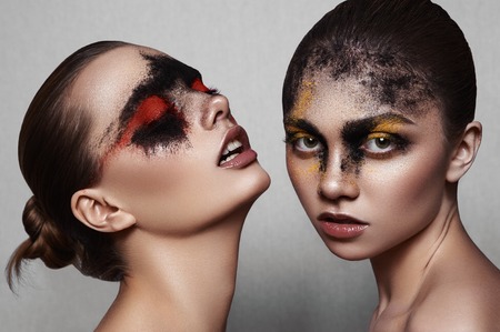 Beauty fashion Models with art Makeup on shiny Skinの写真素材