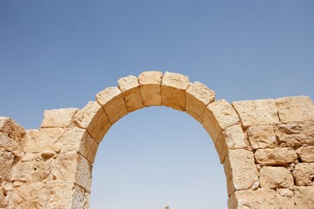 Ruins of ancient stone arch on sky background