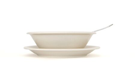 Plain beige soup plate with spoon and saucer side view isolatedの写真素材