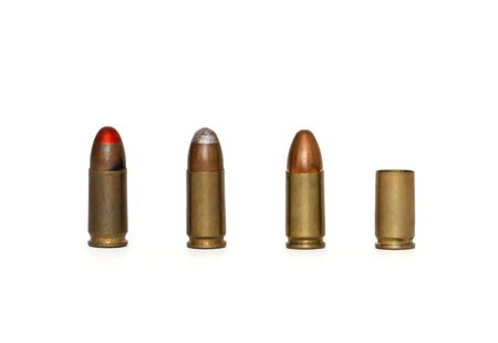Row of three 9mm Parabellum cartridges of several types and spent case isolatedの写真素材