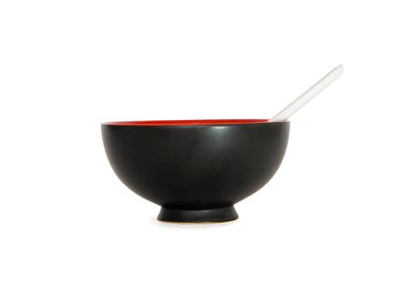 Black Japanese bowl with white spoon side view isolatedの写真素材