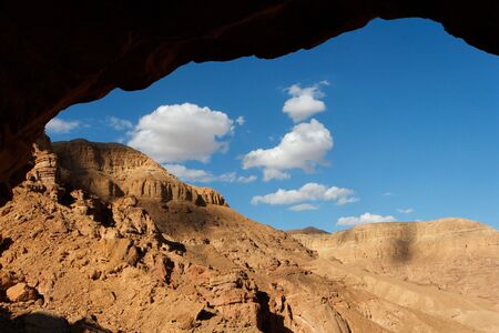Rocky desert landscape seen through the cave entranceの写真素材
