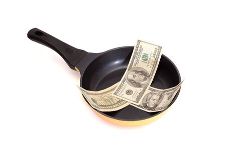 Black frying pan with dollar bills isolatedの写真素材