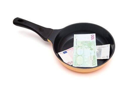 Black frying pan with euro bills isolatedの写真素材