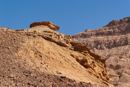 Weathered orange rock on top of dune in desert canyonの写真素材