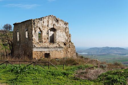 Farmhouse ruin among rural landscapeの写真素材