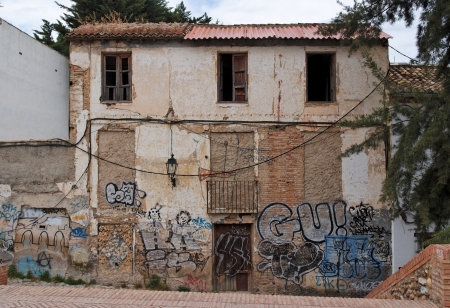 Facade of a deserted house with bricked-up windows and graffitiのeditorial素材