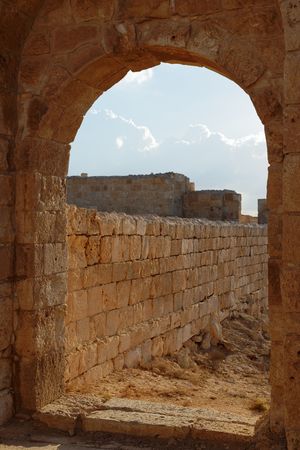 Ancient stone arch and wall at sunsetの写真素材