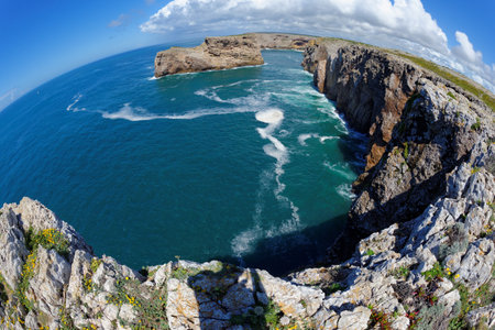 Fisheye view of scenic rocks in the ocean near Cabo de Sao Vicente Cape in the Algarve, Portugal
