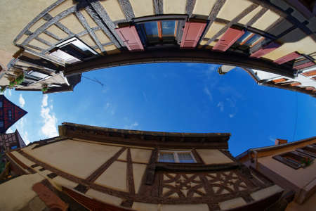 Fisheye view of the sky above a narrow street in Riquewihr town, Alsace, Franceの写真素材