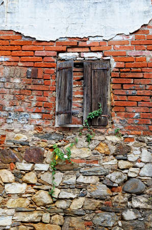 Walled up window in old brick wall with wooden shuttersの写真素材