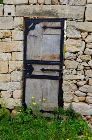 Wooden door in the ancient stone wallの写真素材