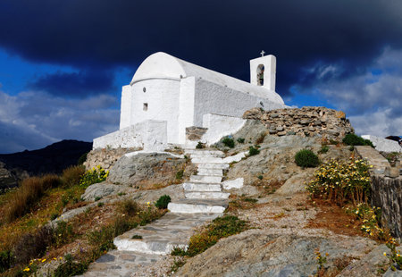Dramatic view of Christian Orthodox church of Agios Konstantinos in the town of Chora in Serifos island, Greece under cloudy skyの写真素材
