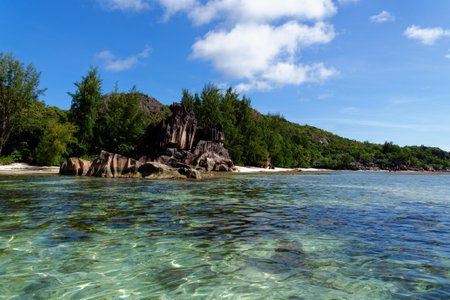 Beach on Curieuse Island, Seychelles, with lava stone rocks and lush vegetationの写真素材