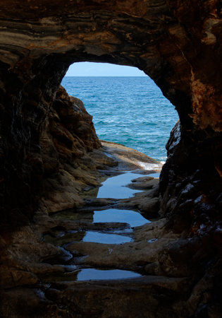 Picturesque sea view through the rock hole near Megalo Livadi on Serifos island in Greeceの写真素材