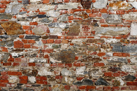 Texture of old wall built of red bricks and uneven stonesの写真素材