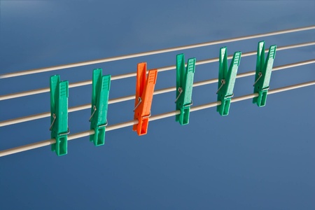 Clothes pins on a wire, one of them standing outの写真素材