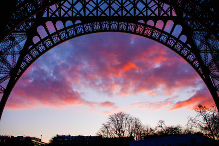 Red clouds through the eiffel tower arc