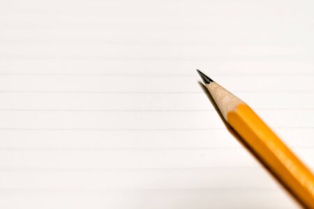 A pencil on clean lined paper. Space for text.の写真素材