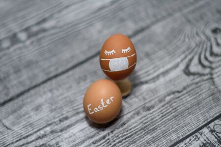 Easter eggs and Coronavirus covid-19. Two brown chicken eggs on the wooden background. Concept on...