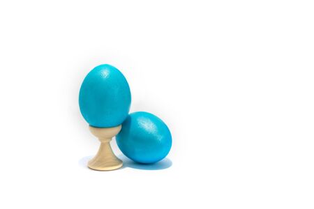 Two colored easter chicken eggs isolated on the white background. One is in holder.の写真素材
