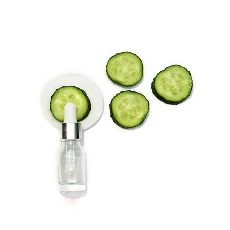 A cosmetic bottle and many sliced cucumbers on the white background. Natural cosmetics.の写真素材