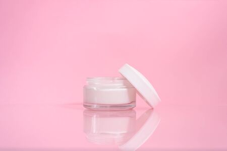 Opened jar of facial or body cream on the pink background. Nature skin care.の写真素材